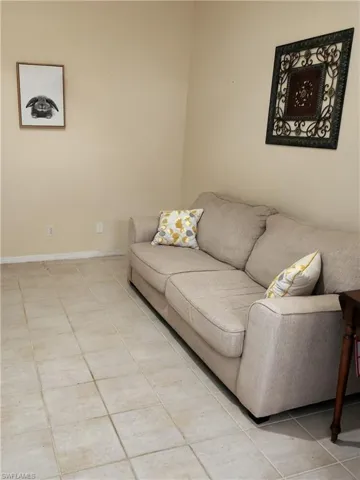 Living area featuring light tile patterned floors and baseboards