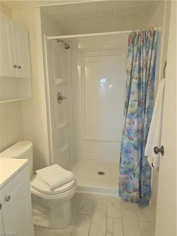 Full bath with a shower stall and vanity
