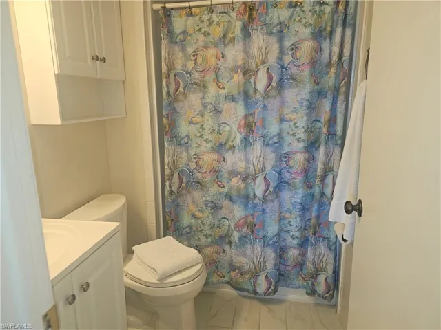 Full bath featuring curtained shower and vanity