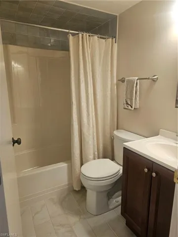 Full guest bath featuring vanity and shower / bathtub combination with curtain