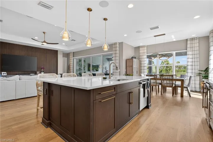 Spacious kitchen island with white countertop, dark wood-finish cabinetry, and gold-tone hardware