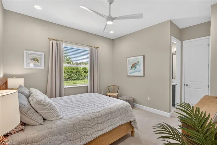 Carpeted interior space featuring a window with exterior shrubbery, recessed lighting, and a ceiling fan