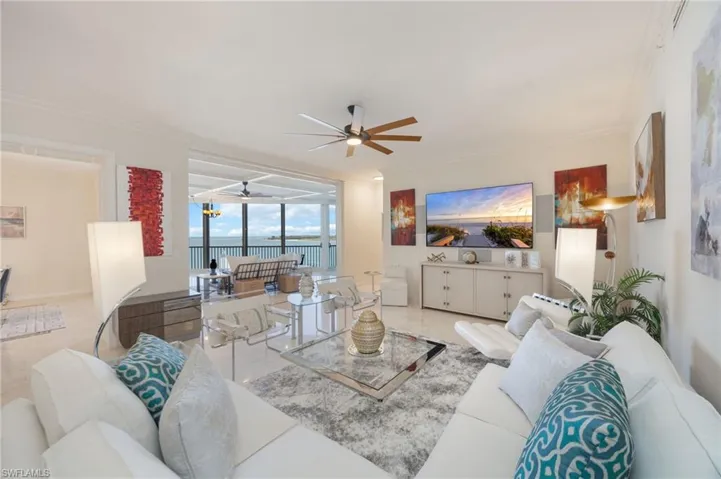 Tiled living room featuring crown molding and a ceiling fan