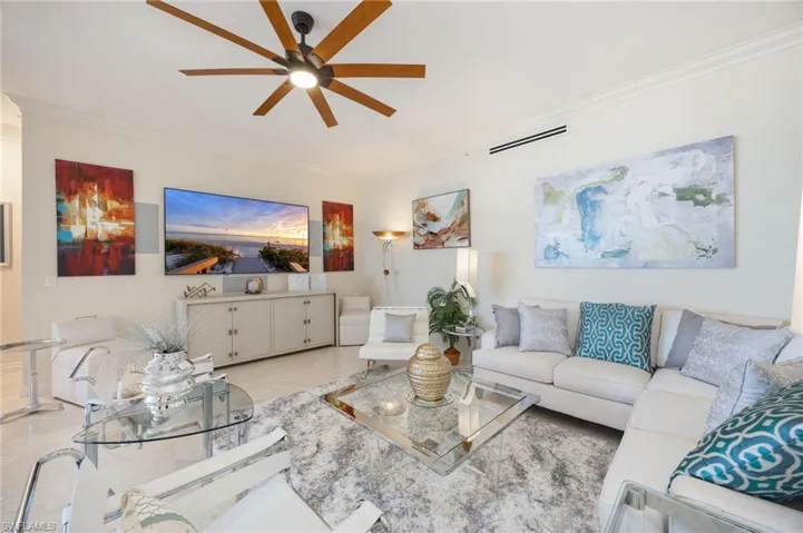 Living area featuring crown molding and ceiling fan
