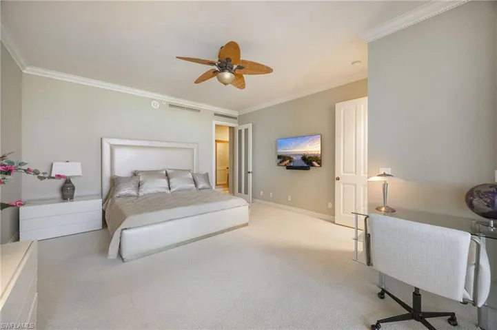 Bedroom with ornamental molding, carpet, and a ceiling fan