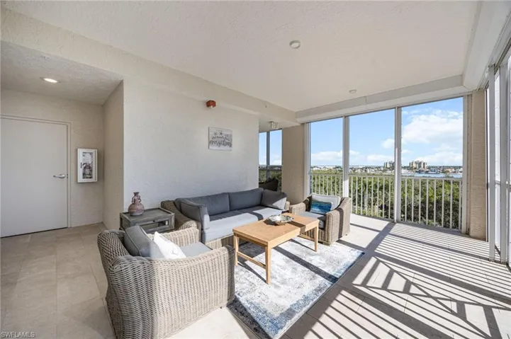 Sunroom / solarium with expansive windows, a textured wall, and a textured ceiling