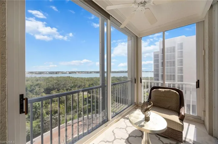 Sunroom with a water view and a wall of windows