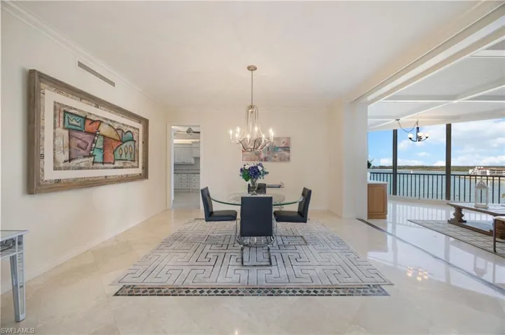 Dining space with a chandelier, floor to ceiling windows, ornamental molding, and a water view