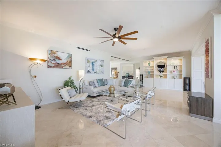 Living area with crown molding and a ceiling fan