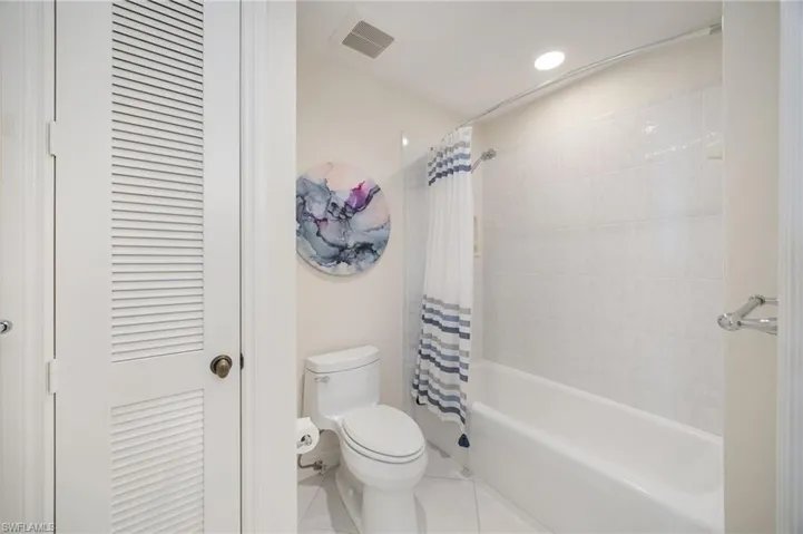 Bathroom featuring shower / bathtub combination with curtain, tile patterned flooring, and recessed lighting
