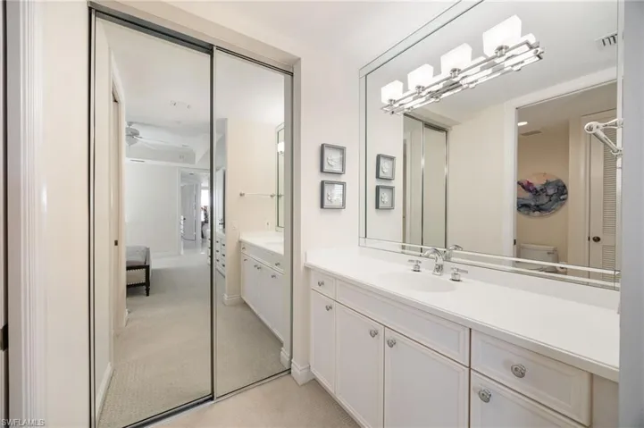 Bathroom with vanity, light colored carpet, and ensuite bathroom