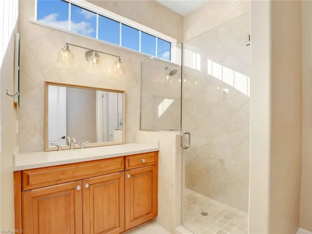 Bathroom featuring a shower with door and vanity