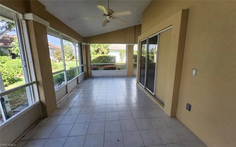 Unfurnished sunroom featuring lofted ceiling and ceiling fan