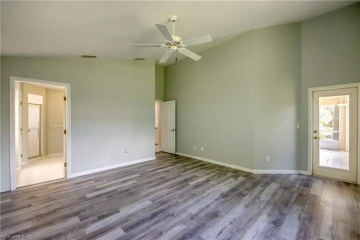 Empty room featuring hardwood / wood-style floors, high vaulted ceiling, and ceiling fan