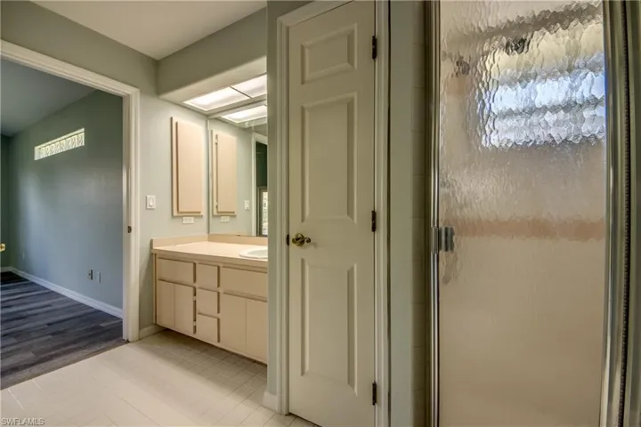 Bathroom with vanity, wood-type flooring, and an enclosed shower