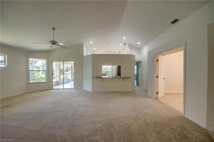 Unfurnished living room with carpet flooring, sink, high vaulted ceiling, and ceiling fan