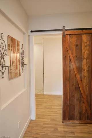 Hallway featuring hardwood / wood-style flooring and a barn door