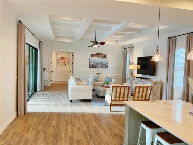 Living room featuring beam ceiling, ceiling fan, and hardwood / wood-style floors