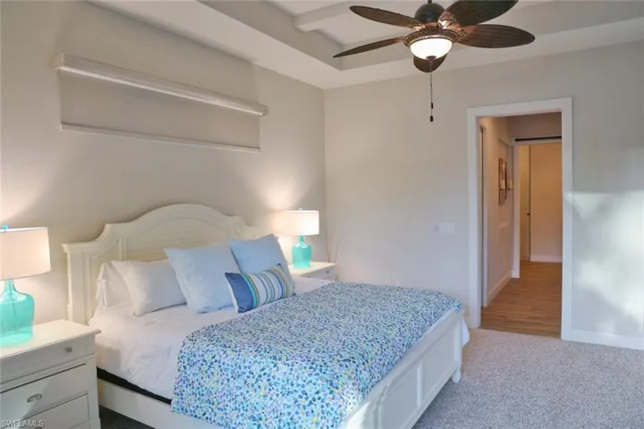 Carpeted bedroom featuring ceiling fan