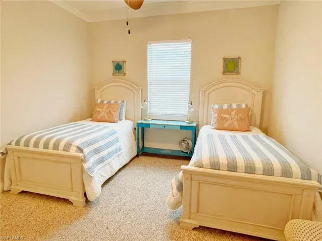 Carpeted bedroom featuring ceiling fan