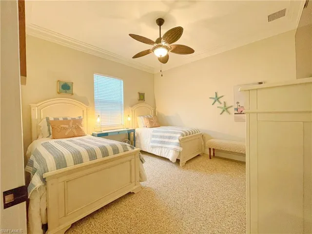 Bedroom featuring ceiling fan, crown molding, and light carpet
