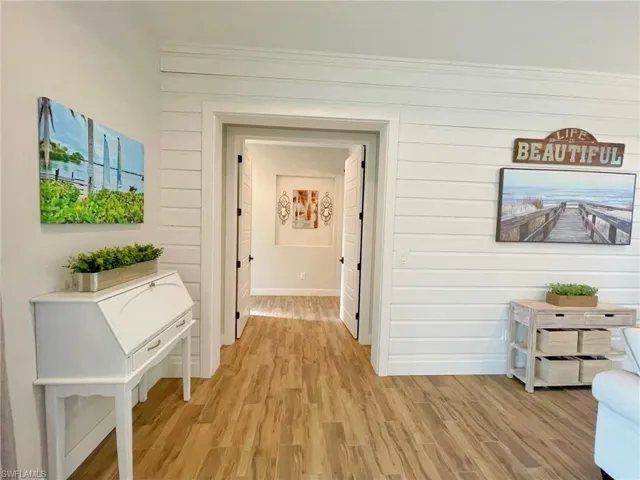 Hall featuring ornamental molding and light wood-type flooring