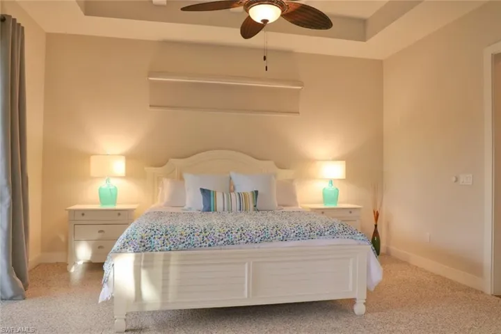 Bedroom with a tray ceiling and ceiling fan
