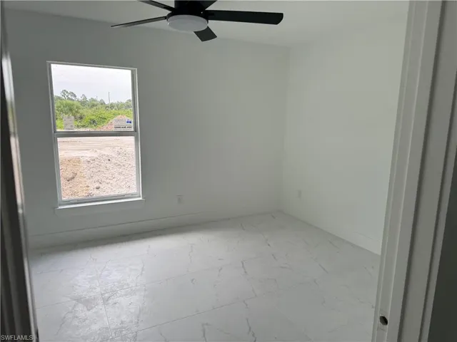 Tiled spare room with ceiling fan