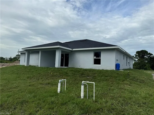 Back of house featuring a lawn
