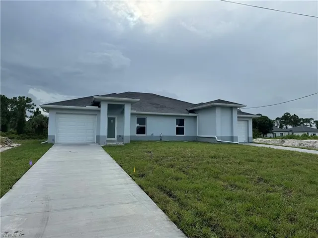 View of front facade with a garage and a front lawn