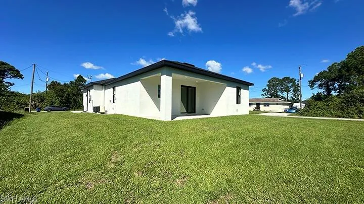 Back of property with a yard, stucco siding, and a patio area