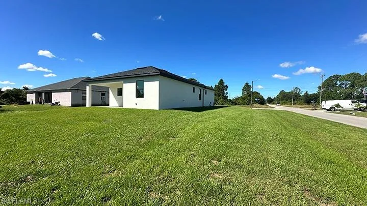 View of home's exterior featuring stucco siding and a lawn