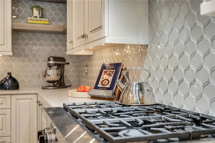 Kitchen featuring commercial cook top and custom backsplash