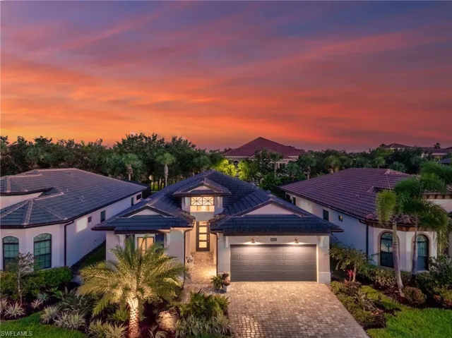 View of front facade with upgraded landscaping and lighting.