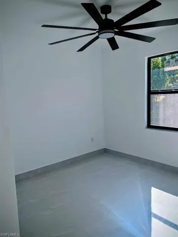 Unfurnished room featuring concrete floors and a ceiling fan