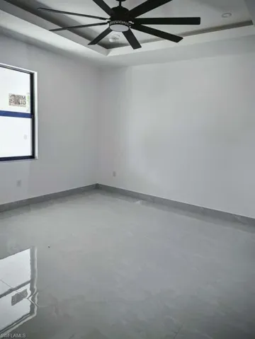 Spare room featuring concrete flooring and baseboards