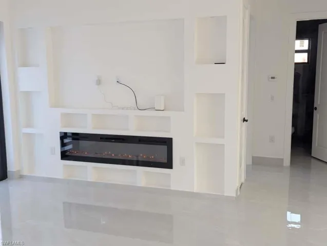 Detailed view of built in shelves and a glass covered fireplace