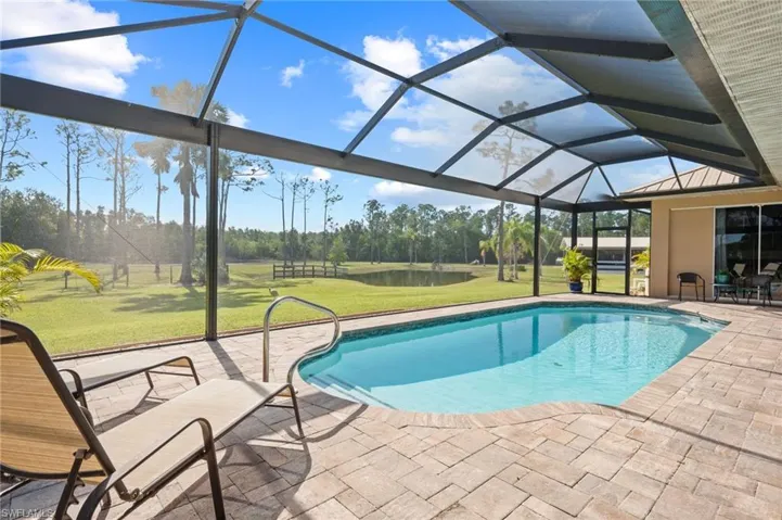 Outdoor pool with a lanai, a patio area, and a yard