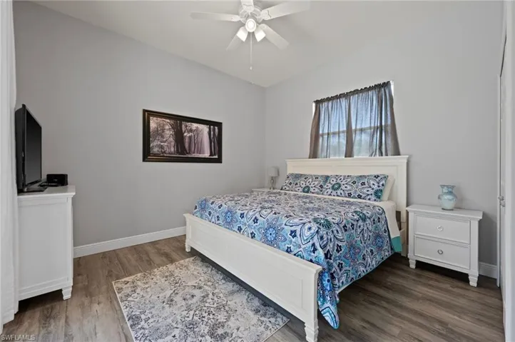 Bedroom featuring ceiling fan, wood finished floors, and baseboards
