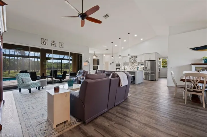 Living area featuring dark wood-style flooring, recessed lighting, visible vents, a ceiling fan, and high vaulted ceiling