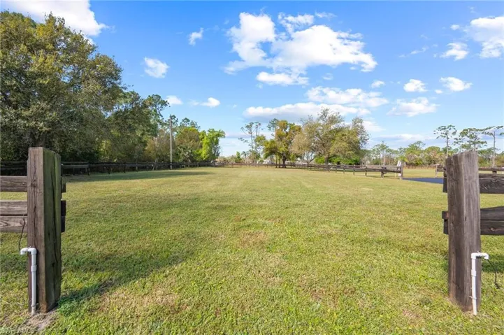 View of yard with a rural view and fence