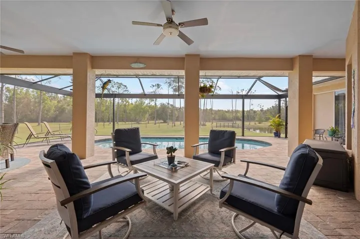 View of patio / terrace featuring ceiling fan, glass enclosure, an outdoor living space, and an outdoor pool