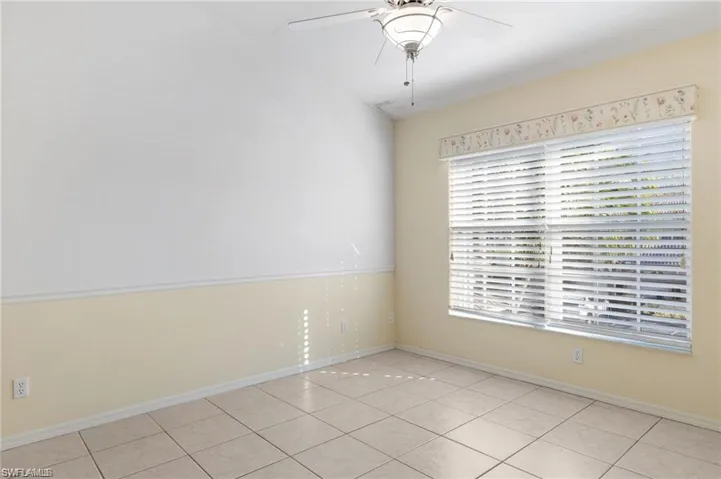 Tiled empty room with ceiling fan and a wealth of natural light