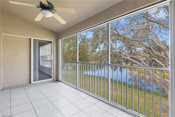 Unfurnished sunroom featuring a water view, ceiling fan, and lofted ceiling