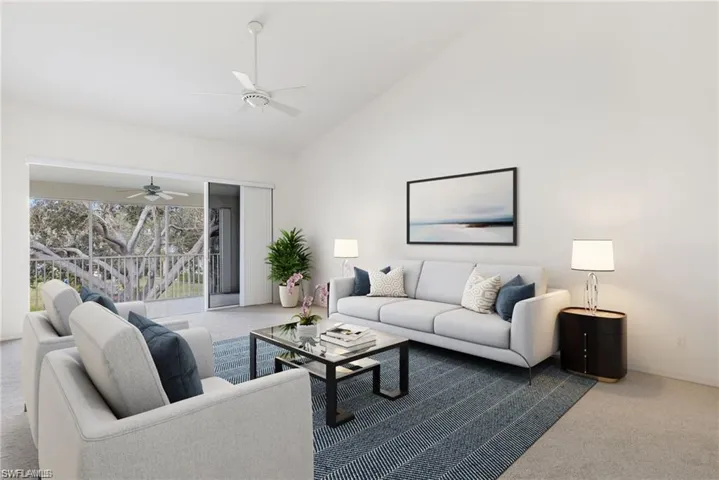 Carpeted living room featuring high vaulted ceiling and ceiling fan