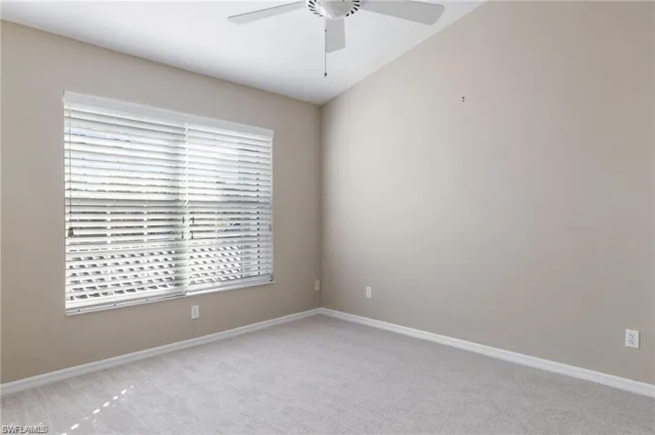 Unfurnished room with carpet floors, ceiling fan, and lofted ceiling