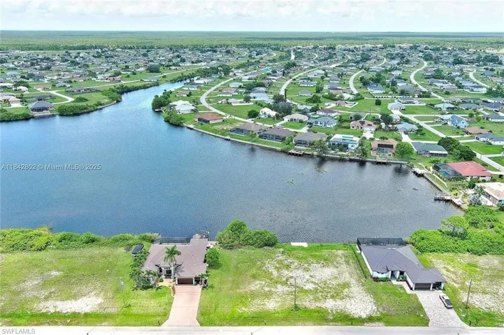 Aerial view of property's location featuring nearby suburban area and a nearby body of water