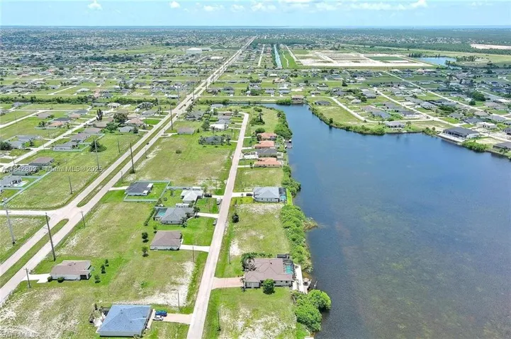 View of property location featuring a large body of water and nearby suburban area