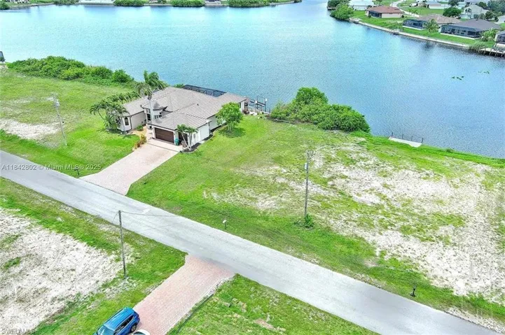 Aerial view of property and surrounding area featuring a nearby body of water