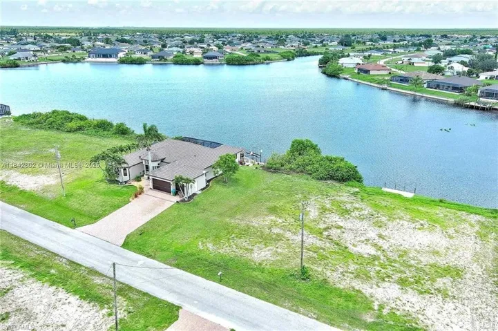 Aerial perspective of suburban area featuring a nearby body of water